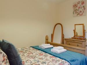 ein Bett mit Handtüchern und einem Spiegel in der Unterkunft Hazel Cottage in Ambleside