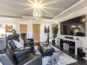 a living room with leather furniture and a large tv at The Paddocks Retreat in North Thoresby