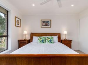 a bedroom with a large bed with two lamps at Spacious and Restful Holiday Home with Backyard in Weetangerra