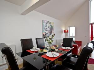 a dining room with a black table and chairs at Bredon Court, Poseidon Penthouse in Newquay
