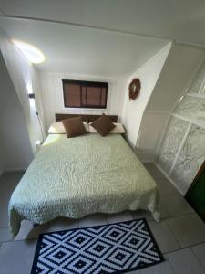 a bedroom with a bed with a green comforter at Cabañas del Maipo in Peumos