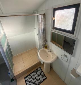 a small bathroom with a sink and a shower at Cabañas del Maipo in Peumos