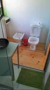 a small bathroom with a toilet and a sink at La casita del bosque en Muelle Delta Arias in Tigre