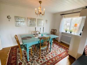 a dining room with a blue table and chairs at 5 person holiday home in Tving in Tving