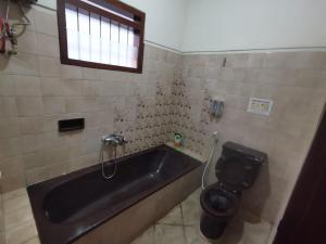 a bathroom with a bath tub and a toilet at Villa Graha Permata 1 in Batu