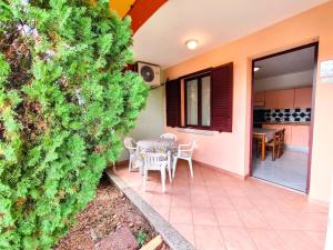 a patio with a table and chairs in a house at Apartment with Pool and Private Parking in Porto Ottiolu
