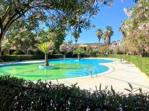 a swimming pool in a resort with palm trees at Apartment with Pool and Private Parking in Porto Ottiolu