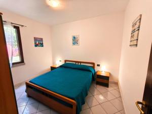 a bedroom with a bed with a green blanket at Apartment with Pool and Private Parking in Porto Ottiolu