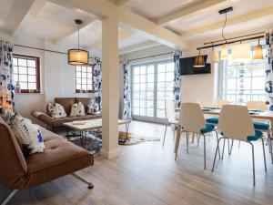 ein Wohnzimmer mit einer Couch und einem Tisch und Stühlen in der Unterkunft Villa Bellevue3 - Apartment 12 in Ahlbeck