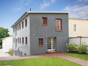 ein graues Haus mit roten Fenstern und einem Hof in der Unterkunft Villa Bellevue3 - Apartment 12 in Ahlbeck