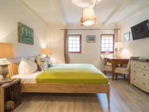 ein Schlafzimmer mit einem Bett, einem Schreibtisch und einem Tisch in der Unterkunft Villa Bellevue3 - Apartment 12 in Ahlbeck