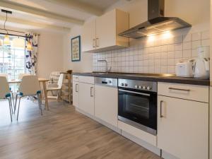 eine Küche mit weißen Schränken und einem Herd mit Backofen in der Unterkunft Villa Bellevue3 - Apartment 12 in Ahlbeck