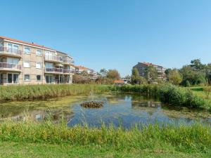 a river with ducks in the water next to buildings at Apartment in Zoutelande near beach in De Zandloper