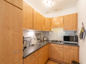 a kitchen with wooden cabinets and a sink at Apartment in Zoutelande near beach in De Zandloper