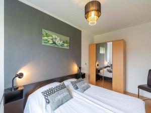 a bedroom with a white bed and a mirror at Apartment in Zoutelande near beach in De Zandloper