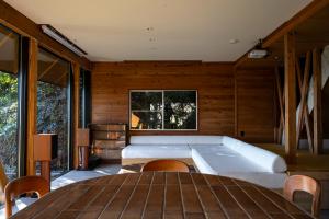 a room with a bed and a table and chairs at tomaru wool -moku- in Atami