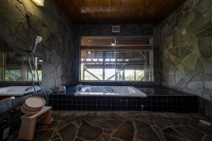 a large bathroom with a tub and a toilet at tomaru wool -moku- in Atami
