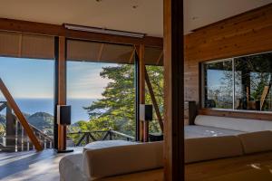 a bedroom with a view of the ocean at tomaru wool -moku- in Atami