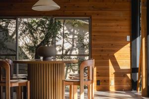 a room with a table and chairs and a window at tomaru wool -moku- in Atami