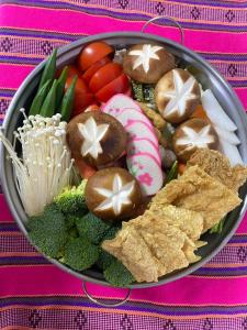 a bowl filled with vegetables and cookies on a table at Lu-Lin B&B in Wufeng