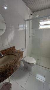 a white bathroom with a toilet and a shower at Res Diego Marcelo DS2 - Casa Completa 2 Dorm, Piscina, AR, WIFI, Churrasqueira in Itapema +24 photos