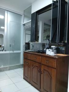 a bathroom with a counter with a mirror and a sink at Suite Umarizal cop30 in Belém