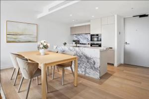 eine Küche und ein Esszimmer mit einem Holztisch und Stühlen in der Unterkunft JEWEL RESIDENCE Luxury Surfers Paradise Apartment with Shared Pool in Gold Coast
