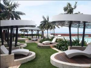 eine Reihe von Bänken mit Palmen und dem Meer in der Unterkunft JEWEL RESIDENCE Luxury Surfers Paradise Apartment with Shared Pool in Gold Coast