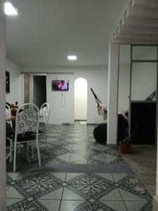 a living room with a tv and a table and chairs at Suite Umarizal cop30 in Belém