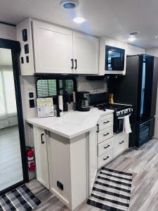 a kitchen with white cabinets and a black refrigerator at Beachfront Retreat w Pool, Boat Ramp & Dock Rental in Key Largo
