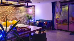 a room with a table and chairs and a brick wall at GARY Suite - Studio Cosy, Spa et jardin privatif à 4 min de Cambrai in Awoingt