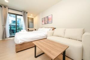 un salon avec un canapé et un lit dans l'établissement New condo near the sea, Laguna, Choeng Thale 324, à Ban Thalat Choeng Thale 32 autres photos