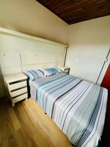 ein kleines Schlafzimmer mit einem Bett und einem Nachttisch in der Unterkunft Acomodação tranquila confortável 15 MT da praia in Florianópolis + 8 Fotos