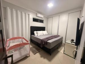 een slaapkamer met een bed en een kinderbedje erin bij Casa Marambaia in Água Boa