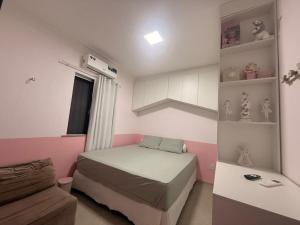 een kleine slaapkamer met een bed en een bank bij Casa Marambaia in Água Boa