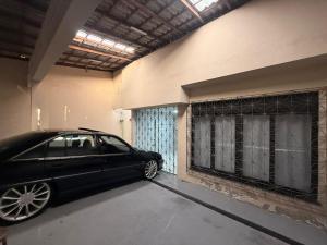 een zwarte auto geparkeerd in de garage van een huis bij Casa Marambaia in Água Boa