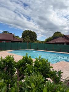 a large swimming pool with a green fence at Cabañas Lomas del mirador in Villa del Dique +11 photos