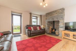 a living room with a couch and a fireplace at Bryn-Weirglodd in Llanfihangel-y-pennant