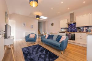 a living room with a couch and two chairs at Bwthyn-Cerrig in Llanerchymedd +17 photos