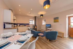 a kitchen and dining room with a table and chairs at Bwthyn-Cerrig in Llanerchymedd