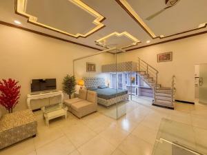 a large living room with a bed and a staircase at The Orchard Haven in Islamabad
