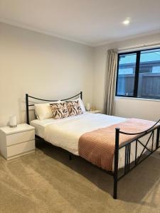 a bedroom with a large bed and a window at Stay with the Singhs in Rolleston
