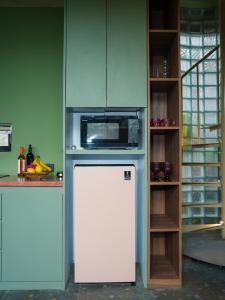 a kitchen with a refrigerator and a microwave at Patha Canggu in Canggu