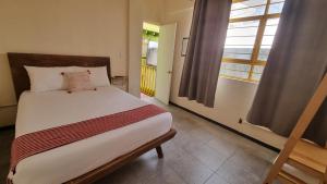 Un dormitorio con una cama y una ventana grande. en Hotel Colonial Guanajuato, en Guanajuato