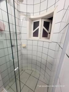 ein Bad mit einer Dusche und einem Fenster in der Unterkunft Casa em Caraguá, uma quadra da praia com ar in Caraguatatuba