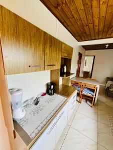 eine Küche mit Holzschränken und einer Arbeitsplatte in der Unterkunft Acomodação tranquila confortável 15 MT da praia in Florianópolis