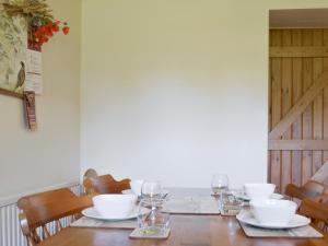 a wooden table with white bowls and glasses on it at Holly Bank in Crich