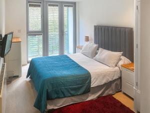 a bedroom with a bed with a blue blanket on it at 12 Zinc in Newquay