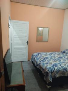 a bedroom with a bed and a door and a mirror at Home in Belém cop 30 in Belém