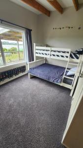 Un dormitorio con dos literas y una ventana. en Paradise HQ Pukenui, en Pukenui